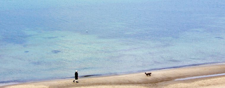 Frau mit Hund am Strand in Kühlungsborn