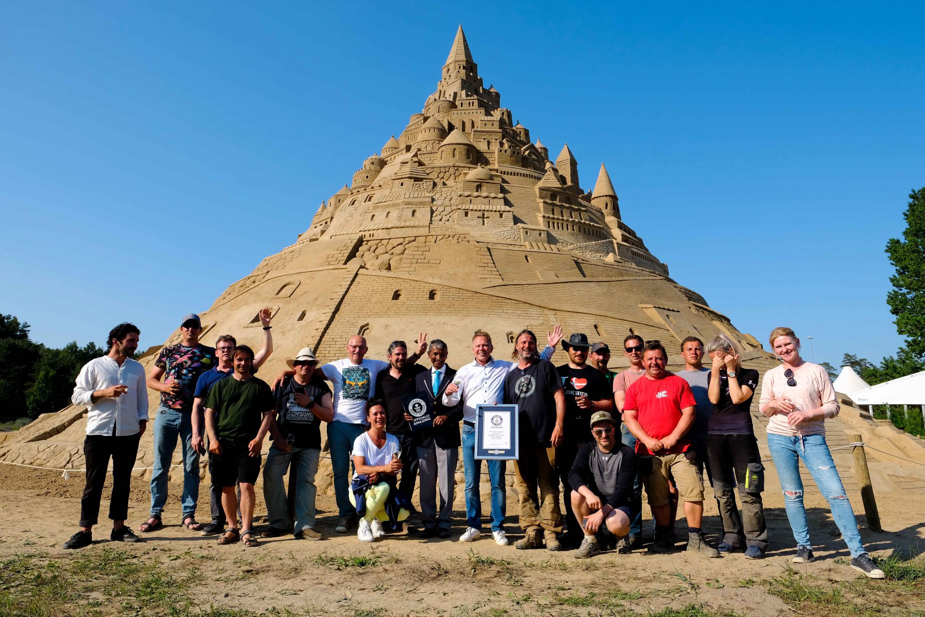 Thomas van den Dungen vom Sandskulpturenfestival in Binz und sein Team vor der höchsten Sandburg der Welt