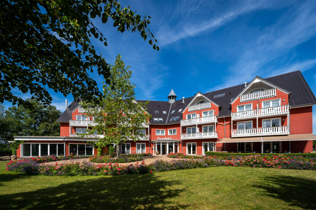 Rote Fassade, großzügige Balkone – das Hotel Strandhafer von Außen
