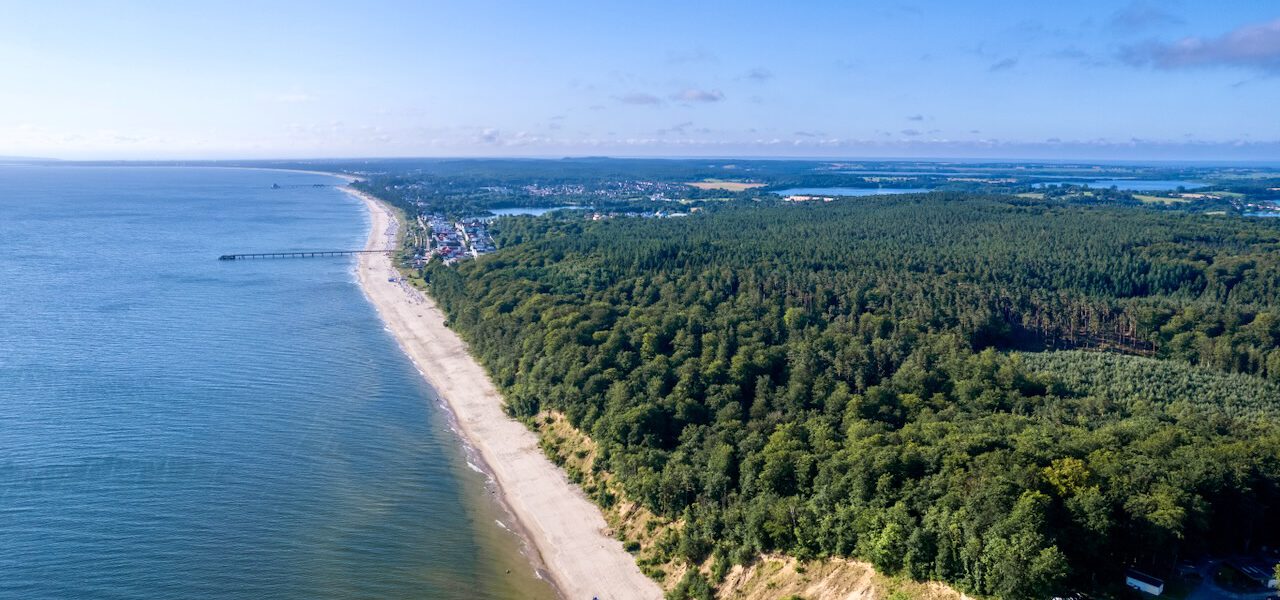 Blick aus der Vogelperspektive auf die Küste von Usedon, blauer Himmel, blaues Meer, grüner Wald