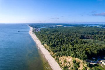 Blick aus der Vogelperspektive auf die Küste von Usedon, blauer Himmel, blaues Meer, grüner Wald